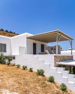 a white house with stairs and a picnic table at Lagadia Village in Antiparos