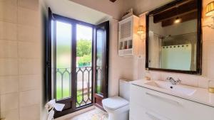 een badkamer met een wastafel en een raam bij Casa vacacional La Coruxa in Vidiago +42 foto's