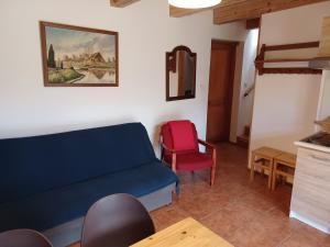 a living room with a blue couch and a red chair at Domki przy lesie in Werblinia