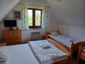 two twin beds in a room with a window at Domki przy lesie in Werblinia