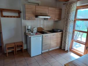 a small kitchen with a stove and a refrigerator at Domki przy lesie in Werblinia +19 photos