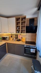 a kitchen with wooden cabinets and a stove top oven at Apartman NAR Murter in Murter