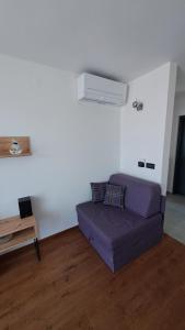 a living room with a purple couch and a table at Apartman NAR Murter in Murter
