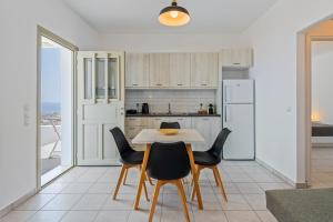 a kitchen with a table and chairs and a refrigerator at Lagadia Village in Antiparos