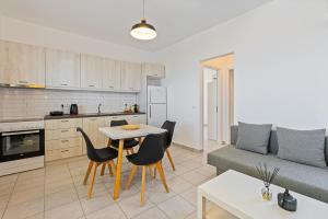 a kitchen and a living room with a table and chairs at Lagadia Village in Antiparos