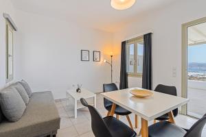 a living room with a table and chairs and a couch at Lagadia Village in Antiparos