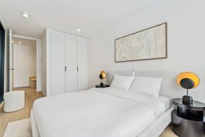1 dormitorio blanco con 1 cama blanca grande y 2 lámparas en Upscale Urban Apartment Style & Comfort for Six, en Luxemburgo