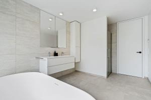 Un baño blanco con lavabo y espejo. en Upscale Urban Apartment Style & Comfort for Six, en Luxemburgo 28 fotos más