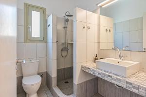 a bathroom with a toilet and a sink at Lagadia Village in Antiparos