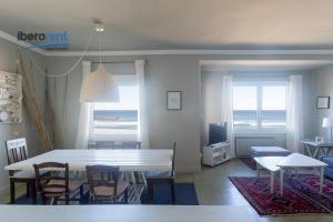 un comedor con mesa y sillas y una habitación con vistas al océano en La Plage Zurriola - IB. Apartments, en San Sebastián