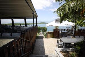 - un restaurant avec des tables, un parasol et l'océan dans l'établissement Hotel Liqeni i Dukagjinit, à Gjakove
