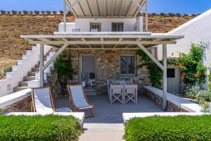 a patio with a table and chairs and a house at Lagadia Village in Antiparos