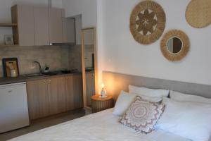 a bedroom with a white bed and a kitchen at House Fedra in Potos