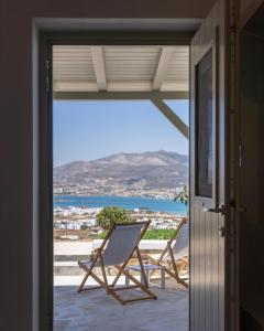 a balcony with a chair and a view of the ocean at Lagadia Village in Antiparos