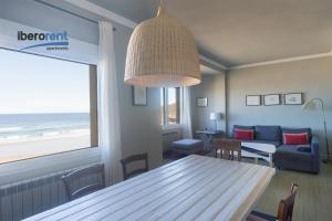 Sala de estar con mesa y vistas al océano en La Plage Zurriola - IB. Apartments, en San Sebastián