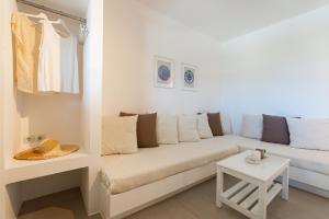 a white living room with a couch and a table at Lagadia Village in Antiparos
