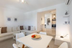 a white living room with a white table and chairs at Lagadia Village in Antiparos