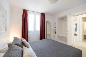 a bedroom with a large bed with red curtains at Lagadia Village in Antiparos