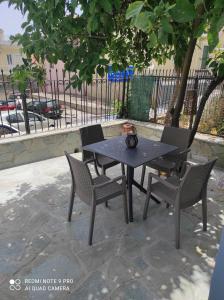 a black table and chairs on a patio at Kalipso home in Mytilene
