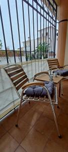 two beds in a room with a large window at San Juan Cozy Home in Benalmádena