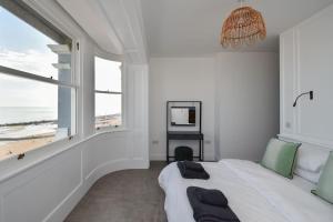 ein weißes Schlafzimmer mit einem Bett und einem großen Fenster in der Unterkunft Amazing Seaview - 2 bedroom, 2 bathroom in St. Leonards