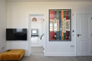 ein weißes Zimmer mit einem Bild an der Tür und ein Schlafzimmer in der Unterkunft Amazing Seaview - 2 bedroom, 2 bathroom in St. Leonards