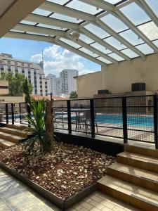 a rooftop patio with a pool and a pergola at Quarto em hotel pertinho do Aeroporto de Congonhas - H2208 in São Paulo