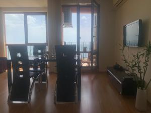 a living room with a table and chairs and a television at Sea view apartment in Sveti Vlas in Elenite
