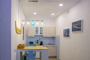 a kitchen with white cabinets and a table with chairs at Umbre de Muri - Riomaggiore - 5 terre in Riomaggiore +12 photos