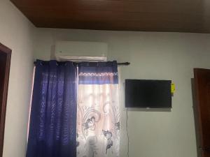 a room with a curtain and a tv in a room at villa mariposa in Santo Domingo