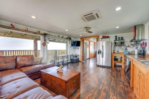 a living room with a brown couch and a kitchen at Waterfront Perry Home Rooftop Deck, Pets Welcome! in Perry