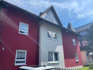 a red and white house with a car parked in front at Visit Oberhof 1 in Oberhof