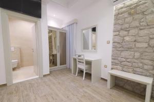 a bathroom with a stone wall and a desk and a chair at Hotel RR in Herceg-Novi +146 photos