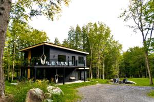 a house in the middle of a forest at Pur Nature et Spa Owl's Head in Mansonville