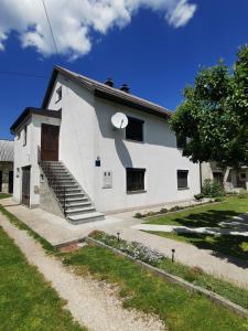 a white house with a large shadow on it at Apartment Milka in Korenica