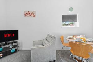a living room with a table and a chair at Your Group Base 3 Modern Flats Sleeps 4 to 12 Near Malvern in Worcester