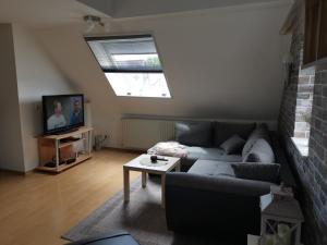 a living room with a couch and a tv at Ferienwohnung Grünberger Land in Grünberg