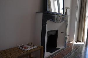 a fireplace in the corner of a living room at Appartement spacieux, confort et climatisé à 500m de la plage in Carqueiranne