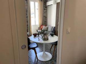 a room with a white table and chairs and a couch at Appartement spacieux, confort et climatisé à 500m de la plage in Carqueiranne