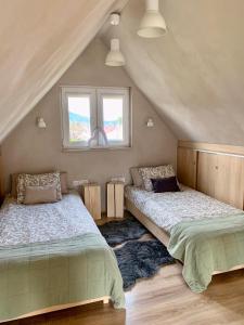 1 dormitorio en el ático con 2 camas y 2 ventanas en Chata na rykowisku, en Ustrzyki Dolne