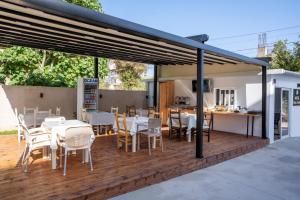 a deck with tables and chairs and a kitchen at Hotel Four Islands in Ksamil