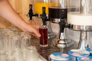 a person holding a glass in front of a machine at Hotel Four Islands in Ksamil