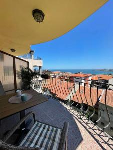a balcony with a table and chairs in a stadium at Moreno in Sozopol