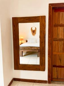 - un miroir dans une chambre avec un lit et une porte dans l'établissement Villa Santa Fé, à Búzios