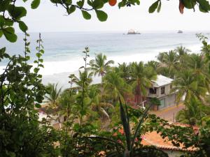 a beach with palm trees and palm trees at La Loma Linda: Bungalows, Yoga and Feldenkrais in Zipolite