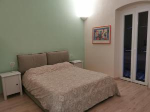 a bedroom with a bed and two tables and a lamp at Kikka's House in La Spezia