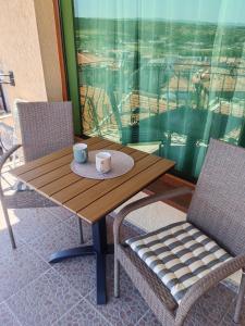 a wooden table with two cups and two chairs at Moreno in Sozopol