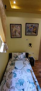 a bedroom with a bed and two pictures on the wall at Hostel Ruler in Belgrade