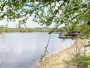 a boat is docked on the shore of a lake at 6 person holiday home in ULLARED-By Traum in Ullared +13 photos