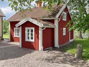 a red shed with white windows on it at 6 person holiday home in Ödeshög in Ödeshög
